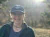 Young woman wearing baseball hat in a sunny field